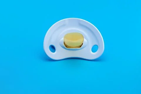 Blue pacifier made of soft silicone  isolated on blue background front view. Stock Photos