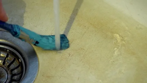 Blue paint is cleaned from a brush under running water 動画素材 101166159