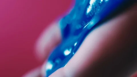 Blue paint flows down the fingers of a woman's hand Stock Footage 81698299