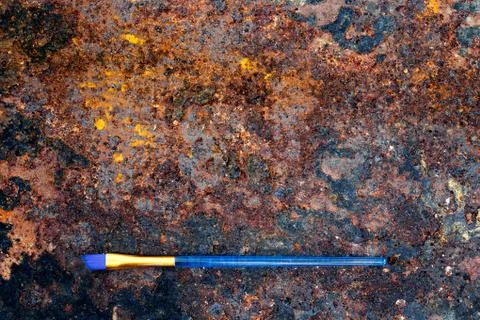 Blue paintbrush on old rusty table, flat lay 库存照片