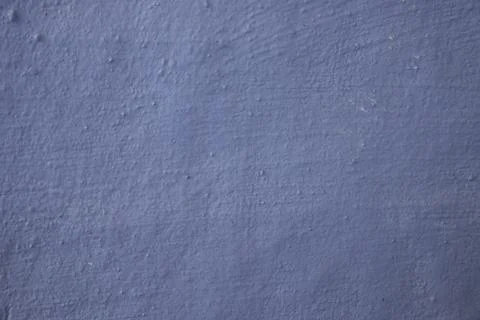 Blue painted wall texture with a rough, uneven surface and subtle grainy details Stock Photos