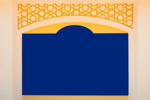 A blue panel sits against a wall with a yellow geometric design. The setting Stock Photos