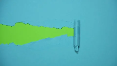 Blue paper background torn in half, revealing a green background that Stock Footage 299031051