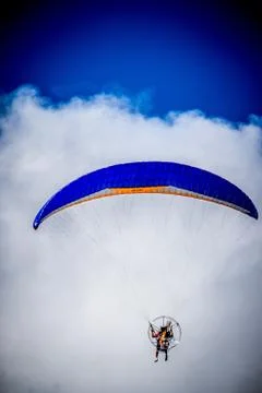 Blue paraglide with clouds Stock Photos