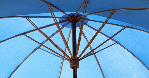 Blue parasol umbrella with reflection sunlight in water Video stock 81806885