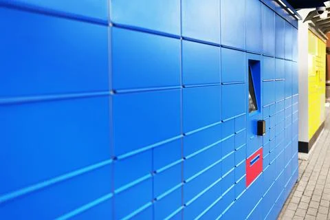 A blue parcel machine designed for receiving packages. The machine features.. Stock Photos