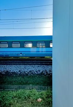 Blue Passenger Train Passing Through Station Platform with Clear Sky Stock Photos