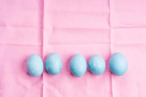 Blue pastel easter eggs on pink table cloth Stock Photos