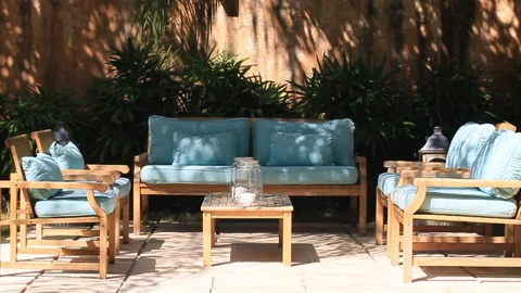 Blue Patio Sofa Set on a Bright Sunny Day with Trees in Slow Motion Stock Footage 185092958
