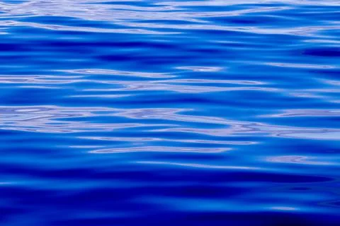 Blue pattern, waves of the ocean, calm sea, nature details. Stock Photos