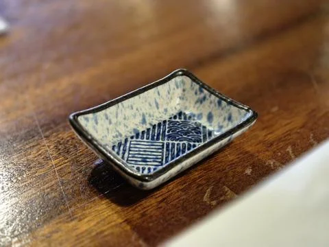 Blue patterned ceramic ring tray on wooden table Stock Photos