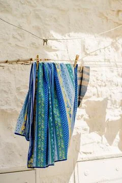 Blue Patterned Fabric Drying on Clothesline beside Limestone Wall in Locoro.. Stock Photos
