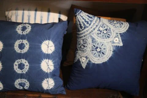 Blue patterned pillows displayed on a dark wooden bench Foto stock