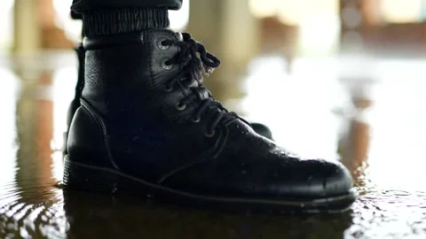 Blue patterned rain boot splashing vigorously into dark Stock Footage 327778229