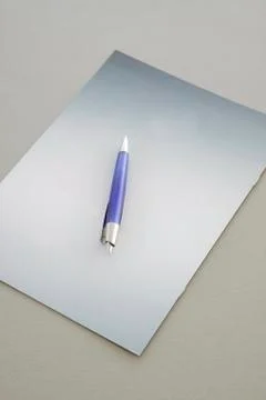Blue Pen on a grey notebook Stock Photos