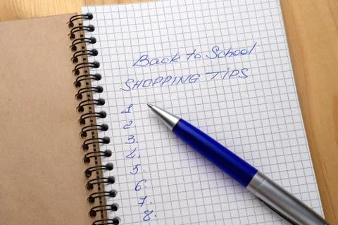 Blue pen on a notebook with sheets in a cage. Sign - back to school and shopp Stock-Fotos