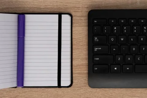 Blue pen on open notepad with keyboard Stock Photos