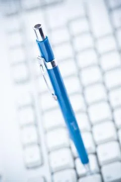 Blue pen on white computer keyboard Foto stock