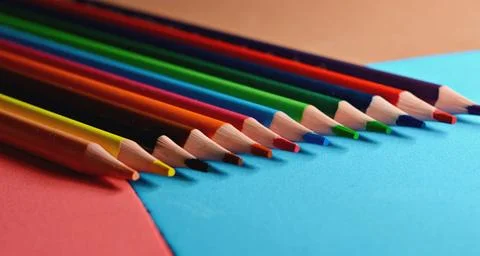 Blue pen with white rests on a stack of colorful foam sheets Foto stock