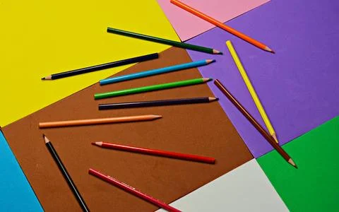 Blue pen with white rests on a stack of colorful foam sheets Stock Photos