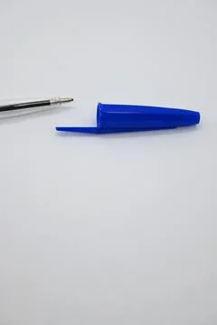 Blue pen without cap next to cap, vulnerability concept, white background, Copy  库存照片