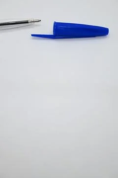 Blue pen without cap next to cap, vulnerability concept, white background, Copy  Stock Photos