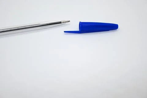 Blue pen without cap next to cap, vulnerability concept, white background, Copy  Фото
