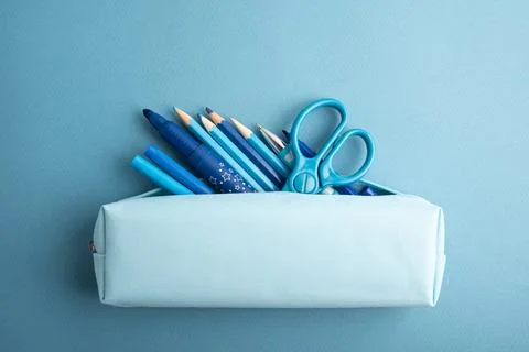 Blue pencil case overflowing with assorted writing and drawing supplies inc.. Stock Photos