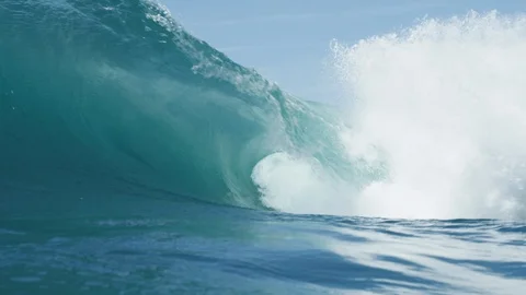Blue perfect wave breaking over shallow reef 4K Stock Footage 128188878