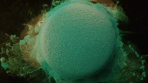 Blue pill dissolving in liquid Stock Footage 255671387