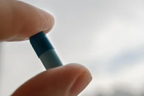 Blue pill in hand close up Stock Photos