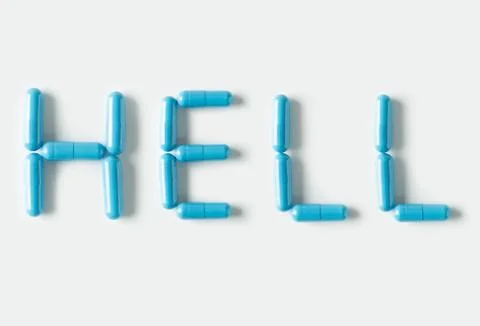 Blue Pills capsules in shape of word Hell. Life concept isolated. Stock Photos