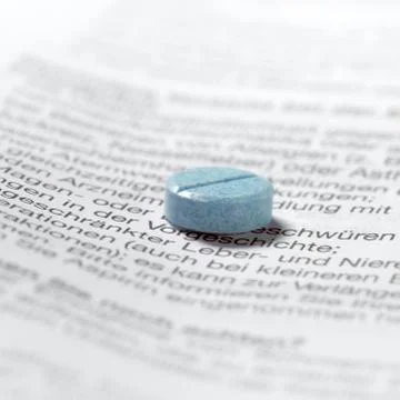 Blue pills on package insert Stock Photos