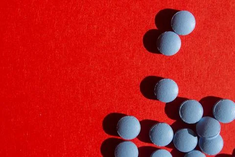 Blue pills on red background Stock Photos