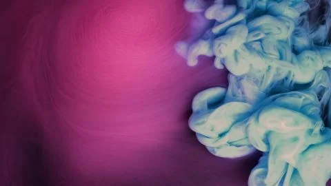 Blue pink clouds of ink in liquid. black background Stock Photos