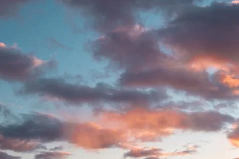 Blue-pink clouds in the light of the setting sun Stock Photos