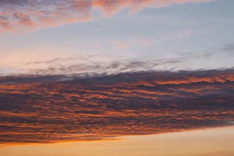 Blue-pink clouds in the light of the setting sun Stock Photos