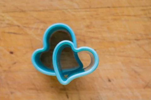 Blue plastic baking molds, forms isolated over wooden background. molds for Foto stock