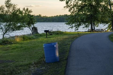 Blue plastic barrel for garbage in a park near Rockland Lake, New York. Stock Photos