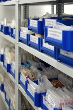 Blue plastic boxes placed in shelves. Stock Photos