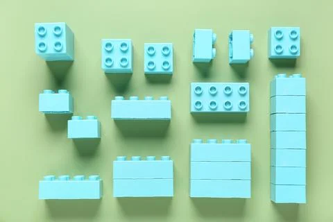 Blue plastic building blocks on green background Stock Photos
