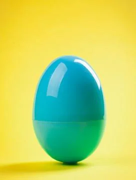 Blue plastic egg close up on yellow background Stock Photos