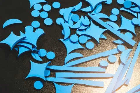 Blue plastic elements shaped like stars and circles lie on the table of an in Stockfoto's