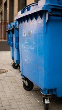 Blue plastic garbage collection containers. In a row on the street Stock Photos