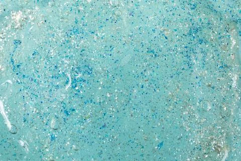 Blue plastic glitter on gel structure close up, abstract texture Stock Photos
