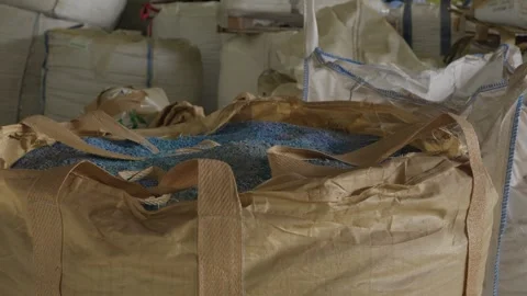 Blue plastic granulate filling open bulk bag at recycling factory Stock Footage 345277279