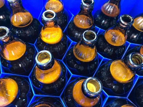 Blue plastic honeycombs shaped case  with full brown glass beer bottles. Stock Photos