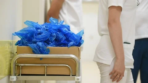 Blue plastic shoes covers in a box inside a hospital Видео 250170030
