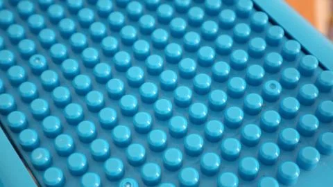 Blue plastic surface showing repeating patterns of circular shapes creating.. Stock Photos