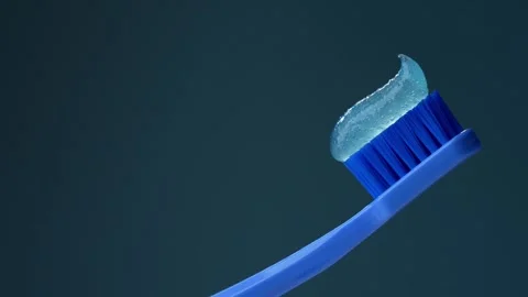 Blue plastic toothbrush with toothpaste on a blue background. Stock Footage 306591621